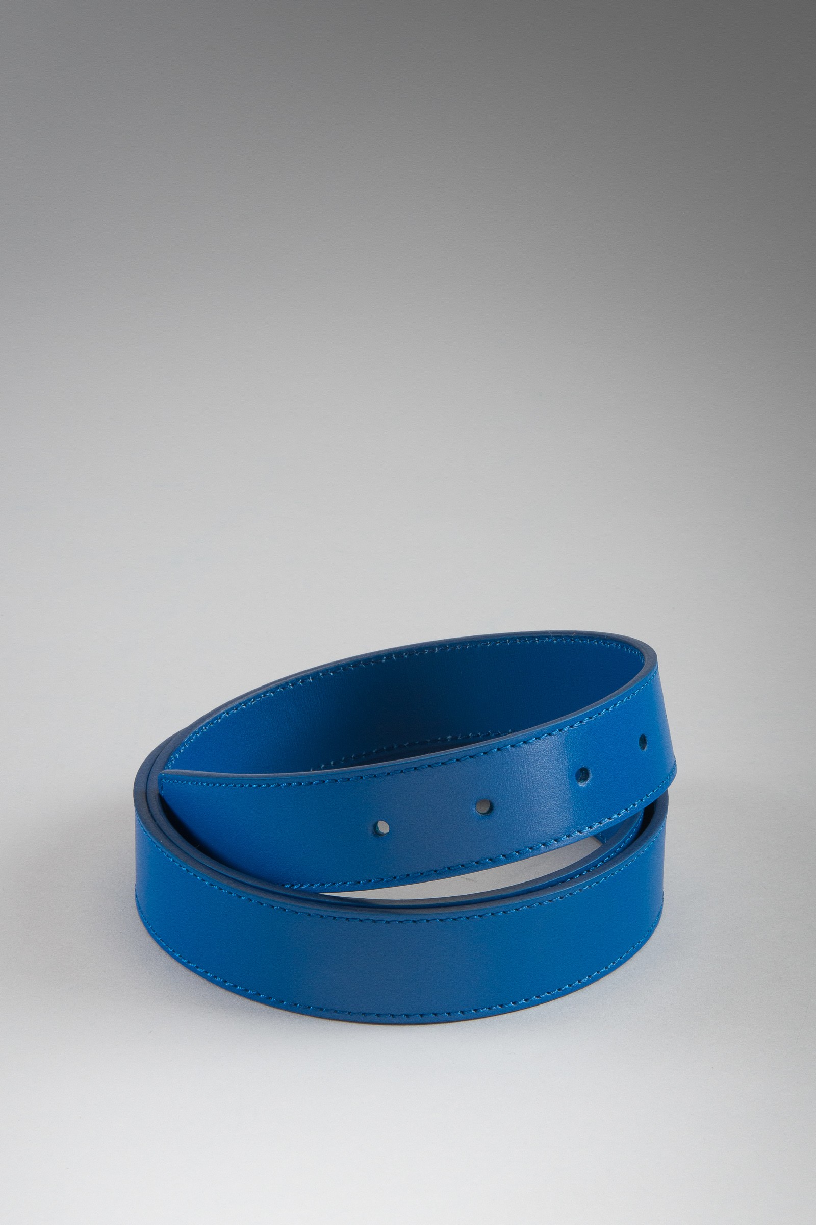 Blue leather belt coiled on a plain gray background, smooth finish